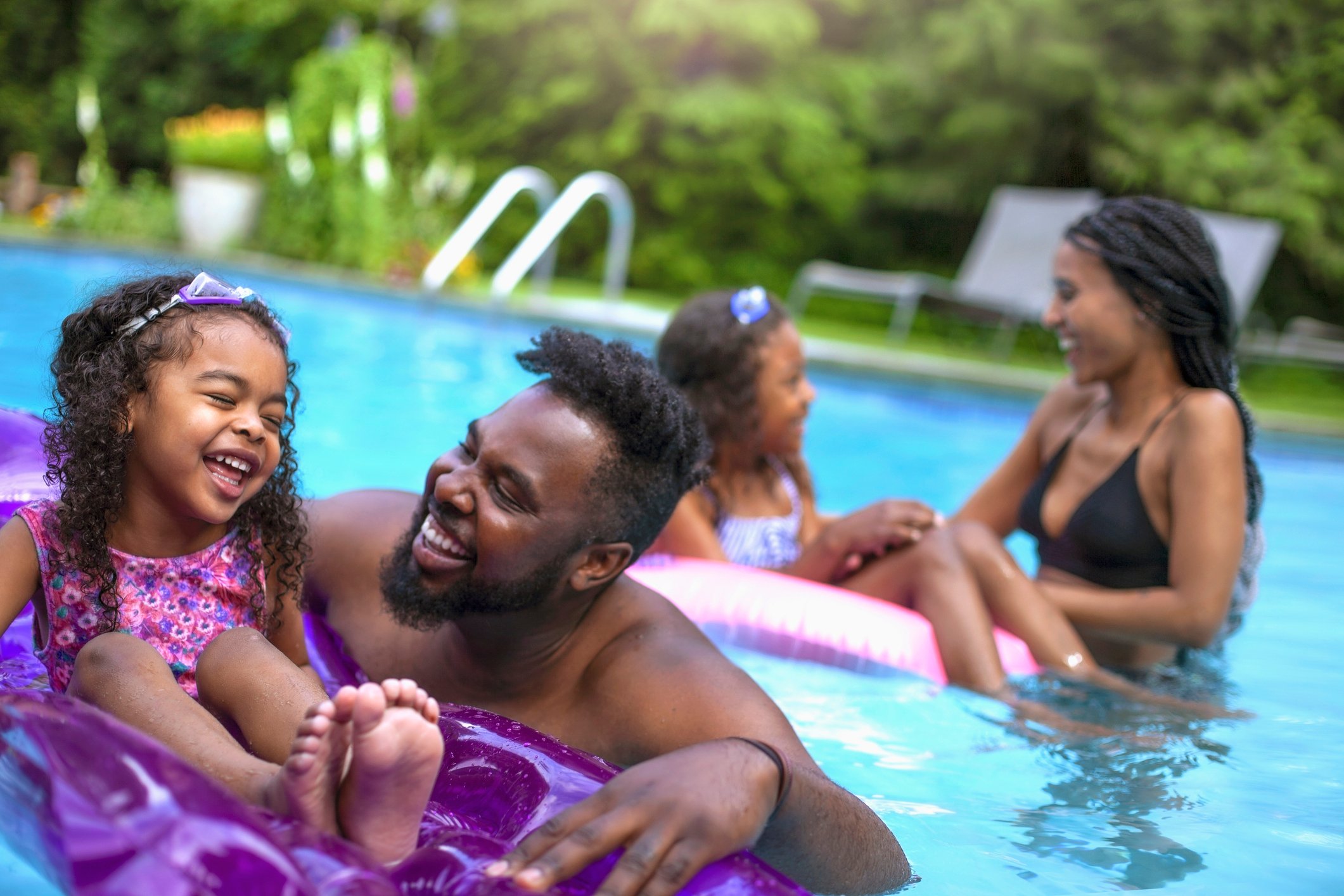 A family in a pool with the two children using floats.