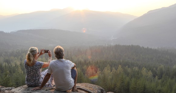 Two people enjoying a scenic view from a mountain top.
