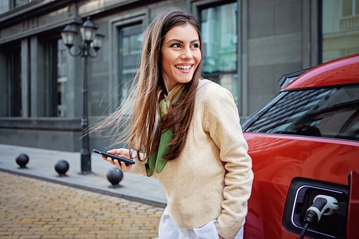 A driver outside an electric car.