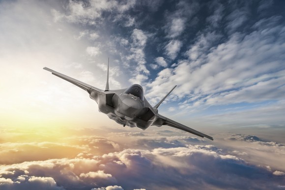 Fighter jet flying over the clouds.