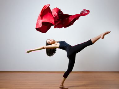Young dancer under a red cape.