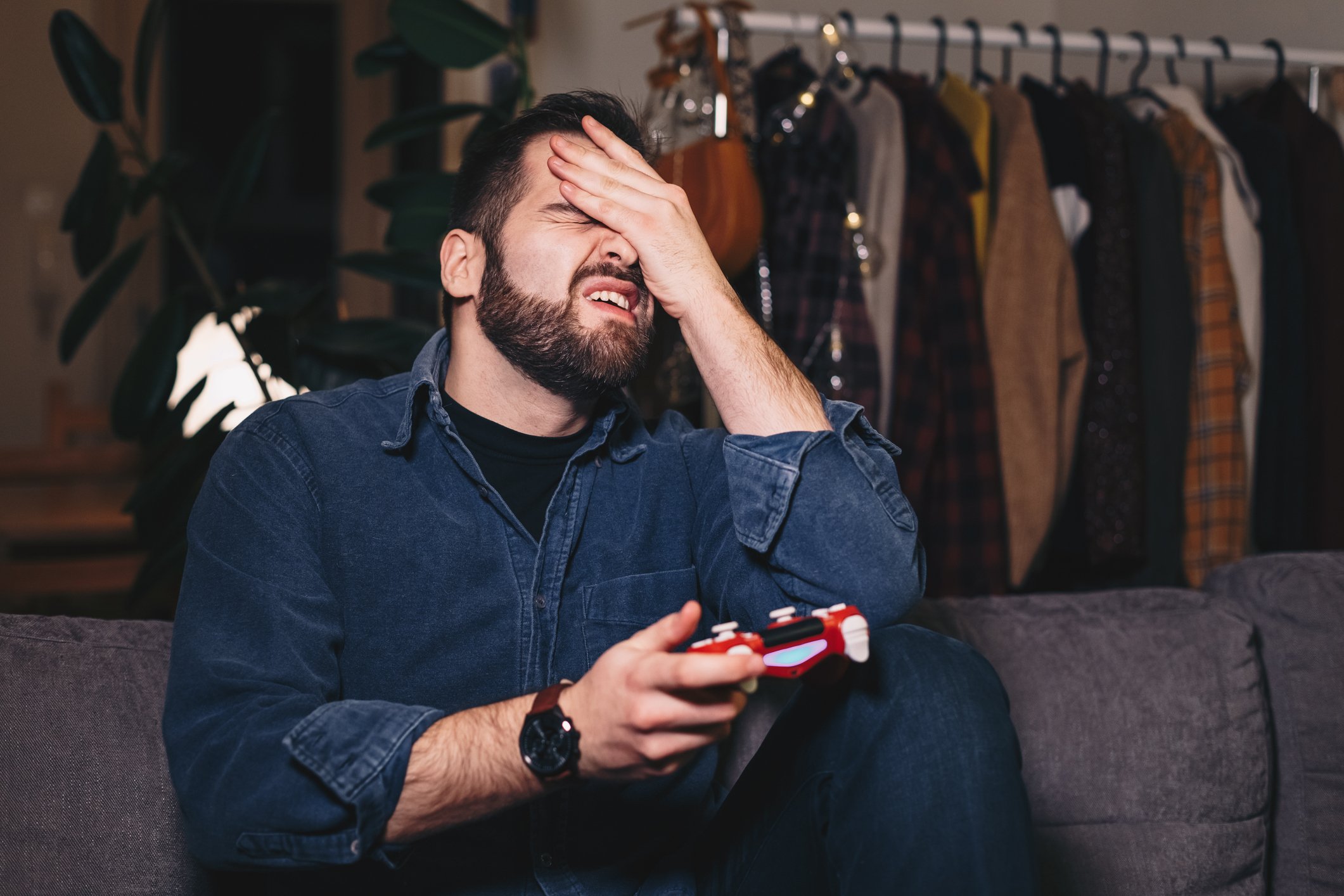 Man playing video games cringing.