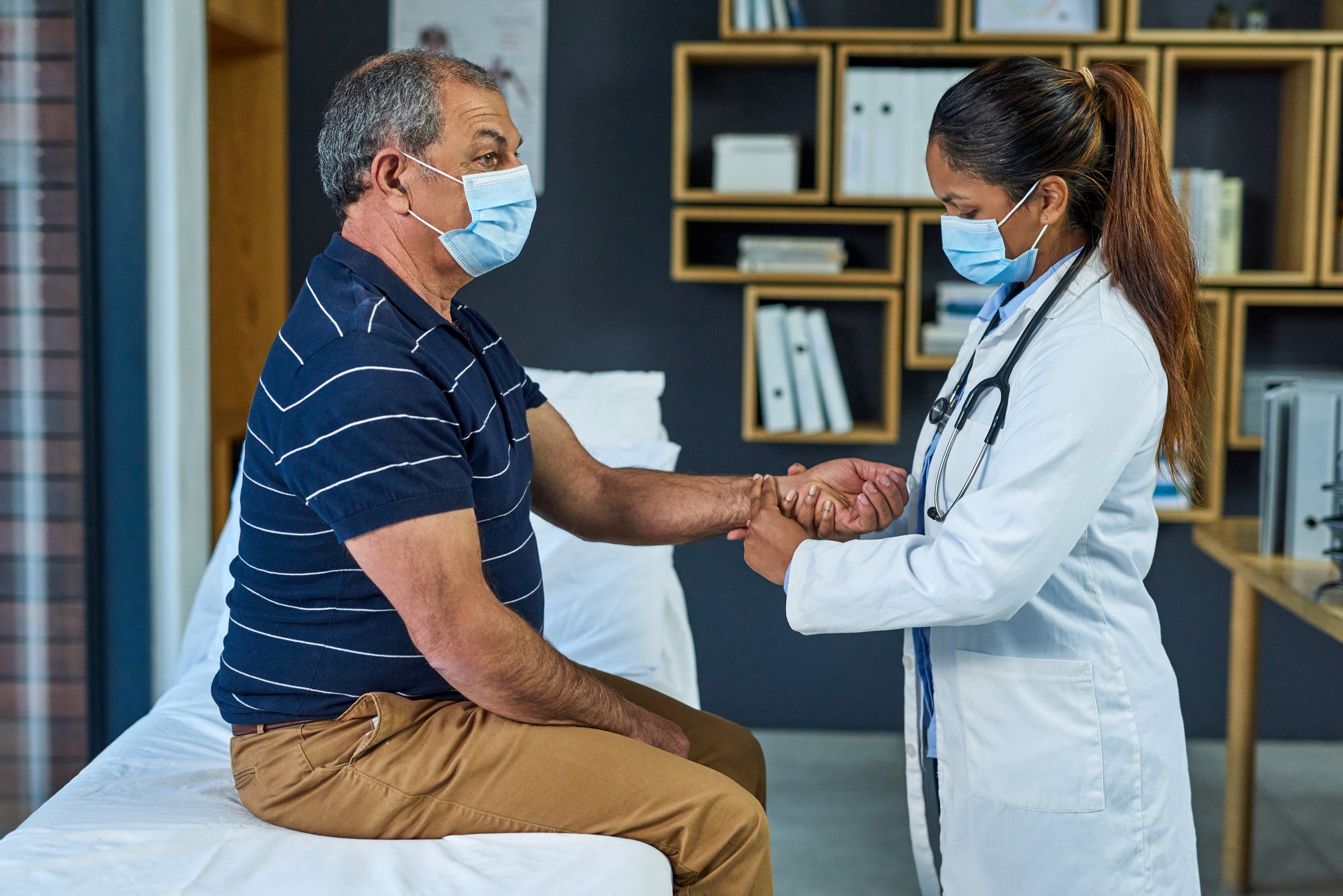 A doctor checks a patient's pulse.