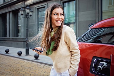 Portrait of woman charging her electric car.