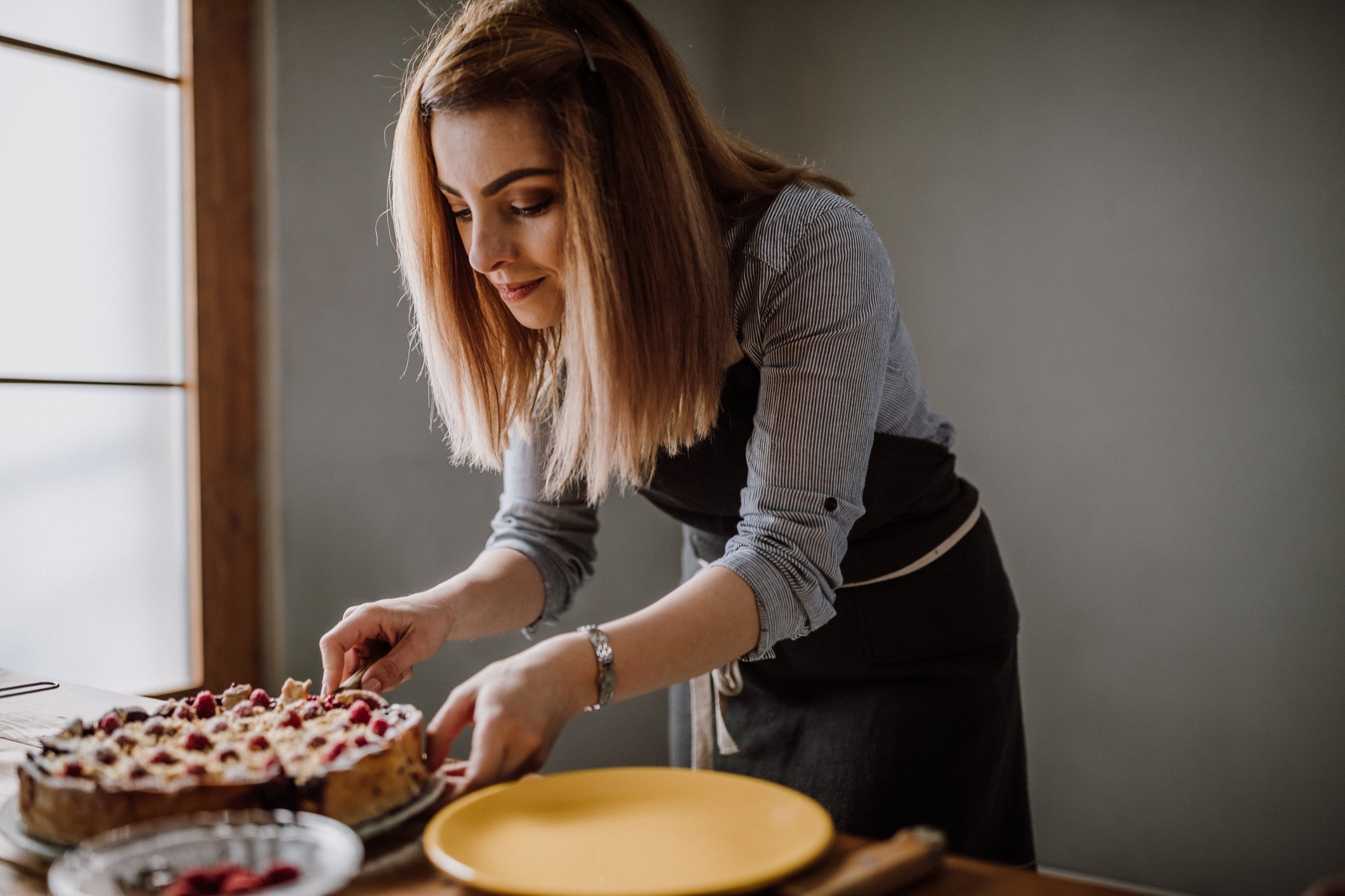 Baker slicing up a berry pie.