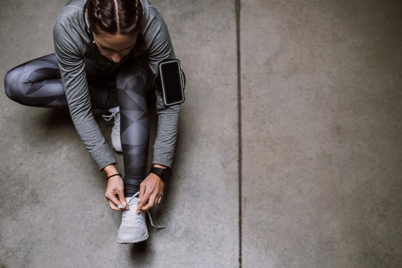 A runner lacing up their shoes for a workout.