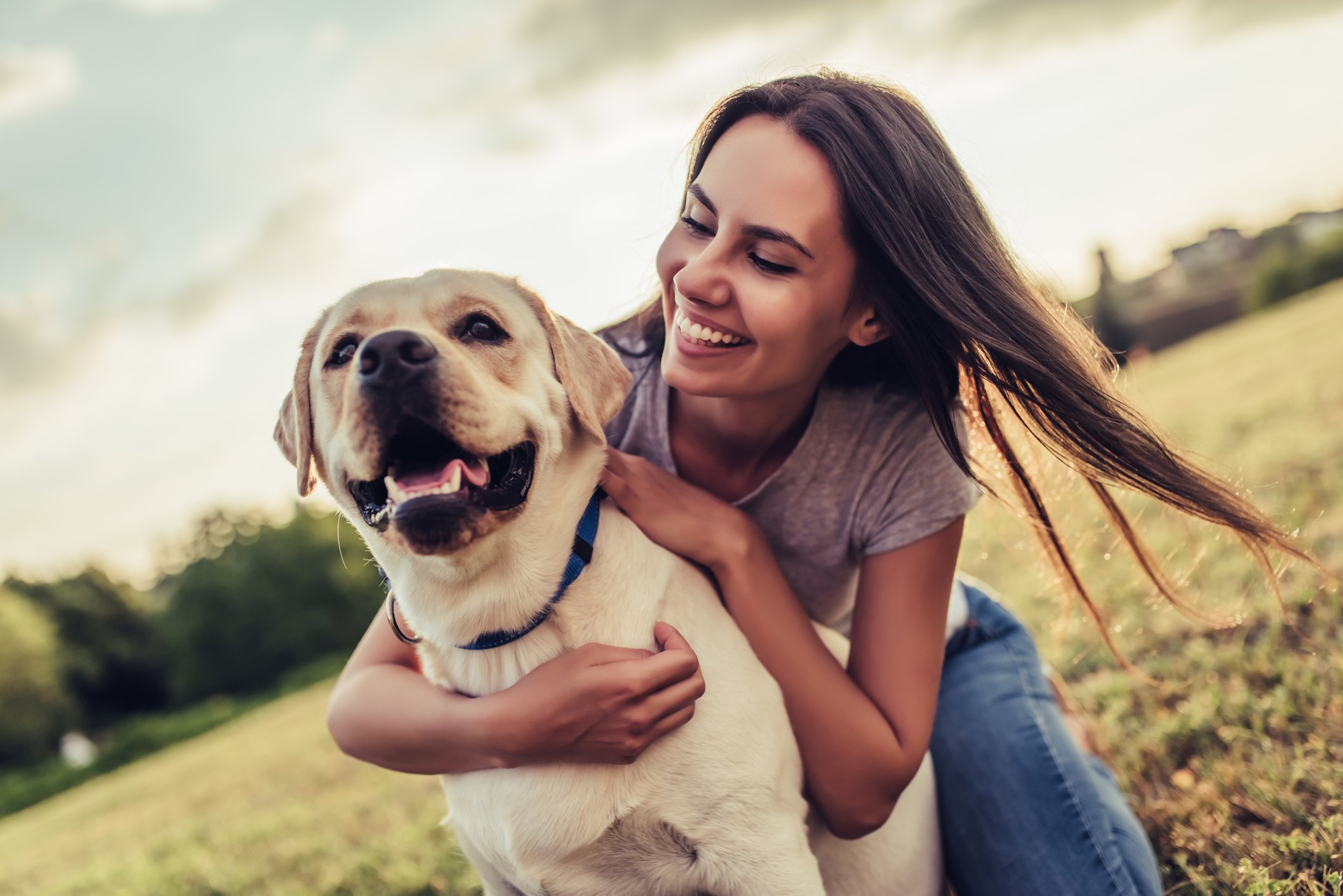 A person hugging a dog.