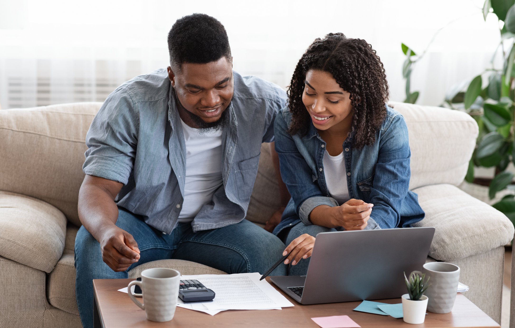 Two smiling people looking at documents.
