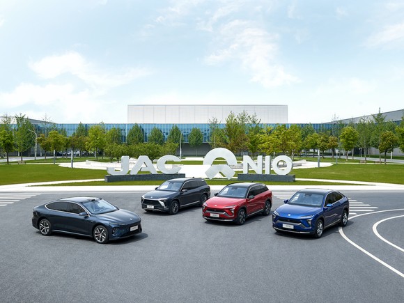 Four Nio electric vehicles in front of a Nio building.