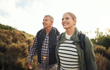 a mature couple hiking through the mountains