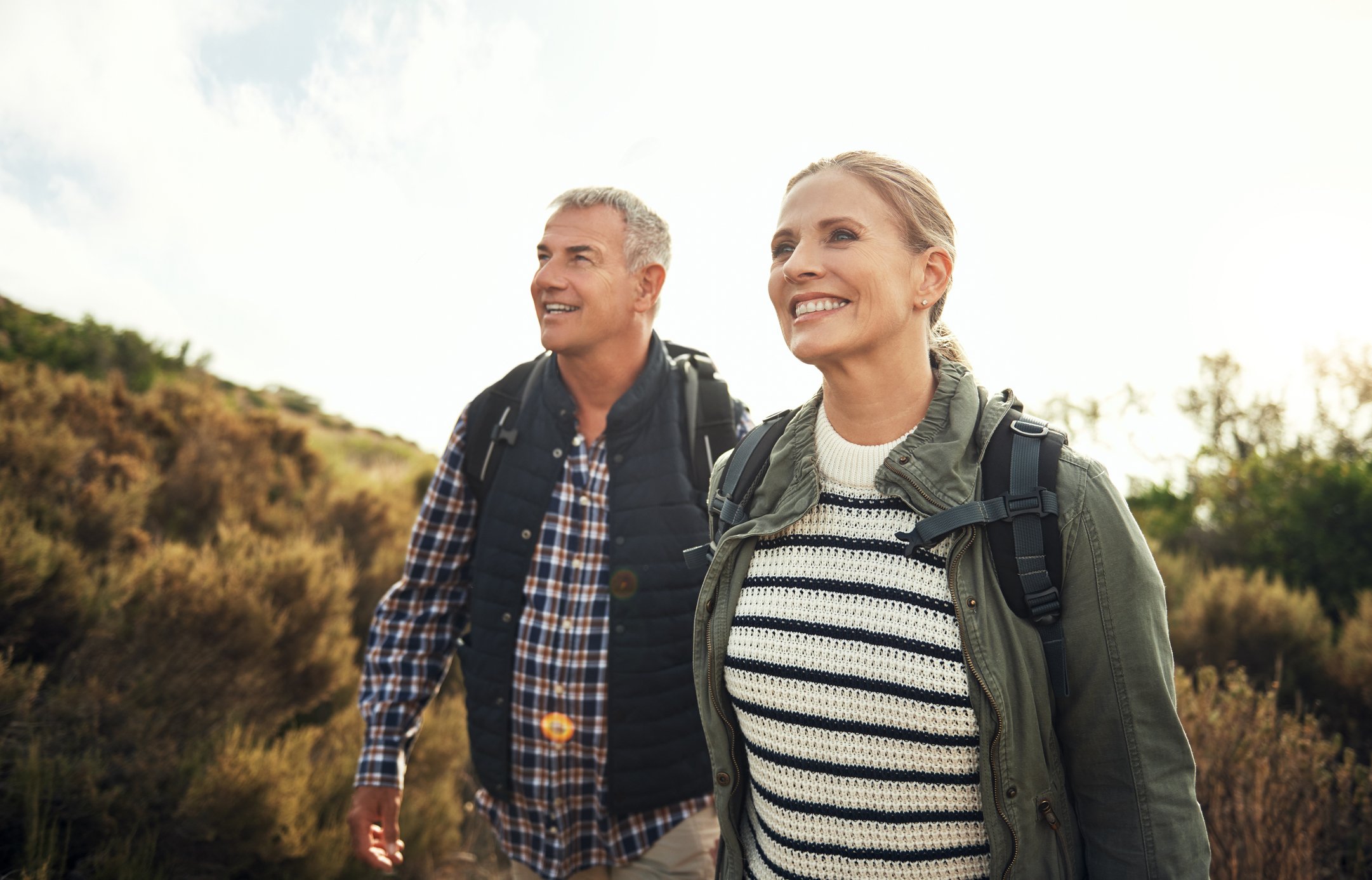 a mature couple hiking through the mountains