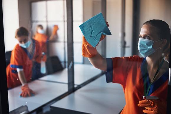 Cleaners cleaning glass.