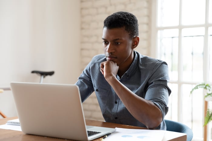 A person with a serious expression at a laptop.