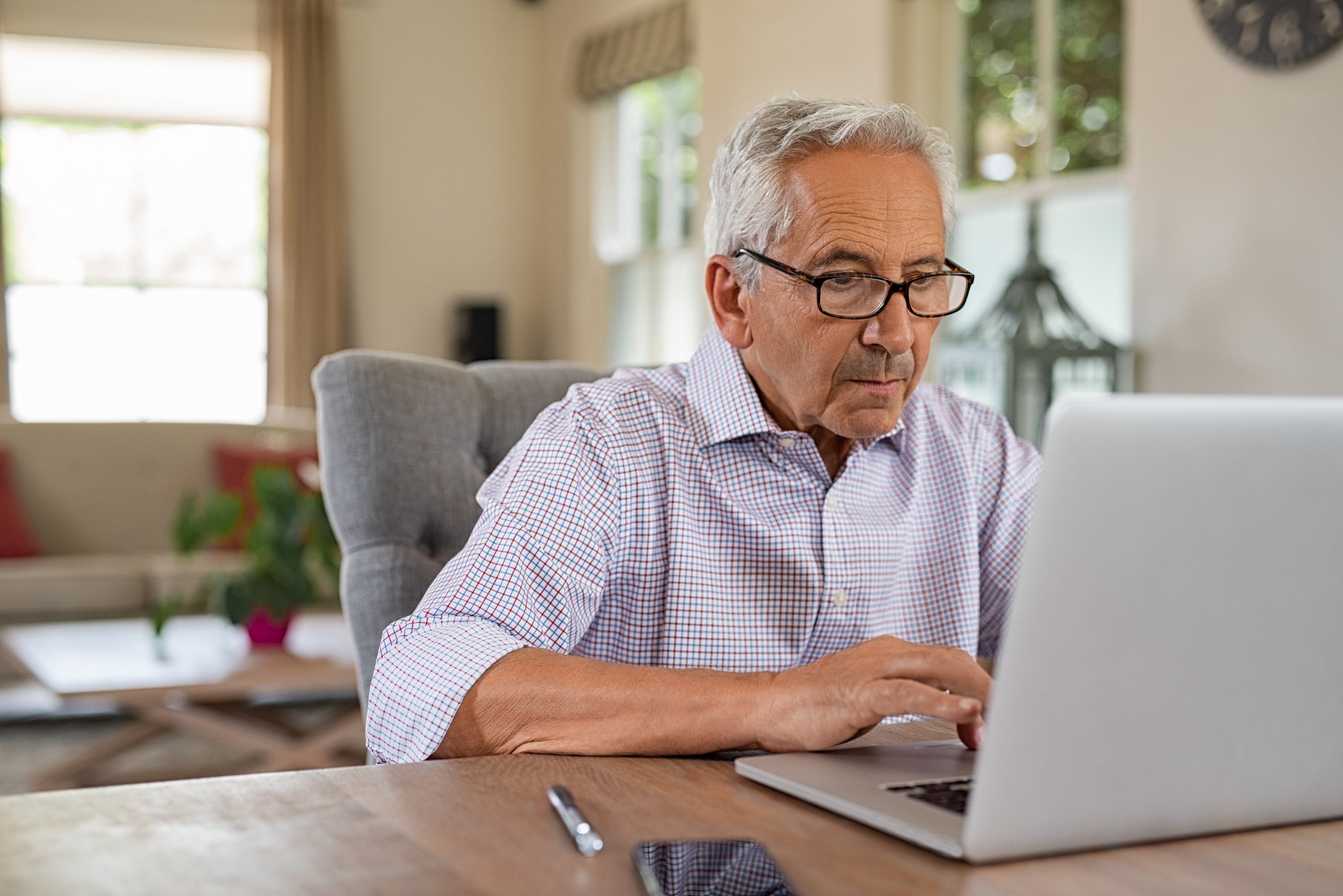 A person with a serious expression at a laptop.