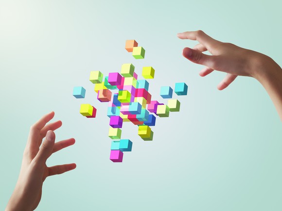 Two hands with augmented reality blocks in between them. 