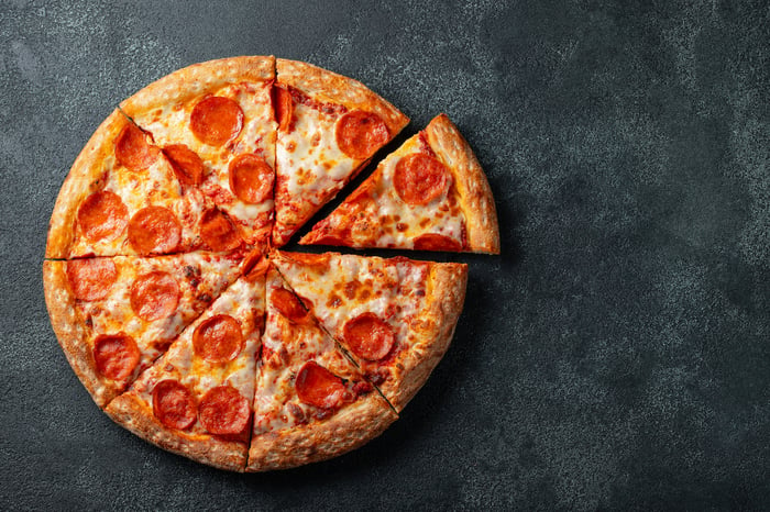 A pepperoni pizza with one slice removed.