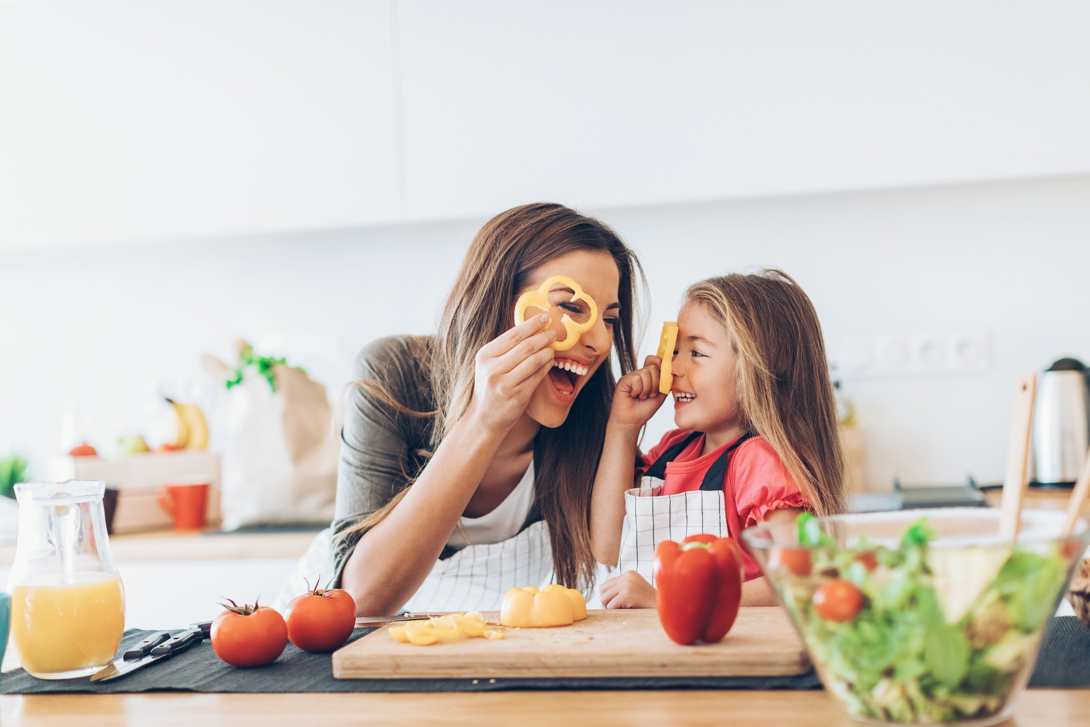 A parent and child cook together.