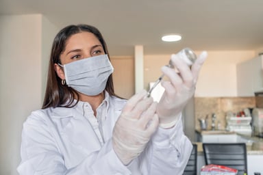 doctor loads syringe with vaccine