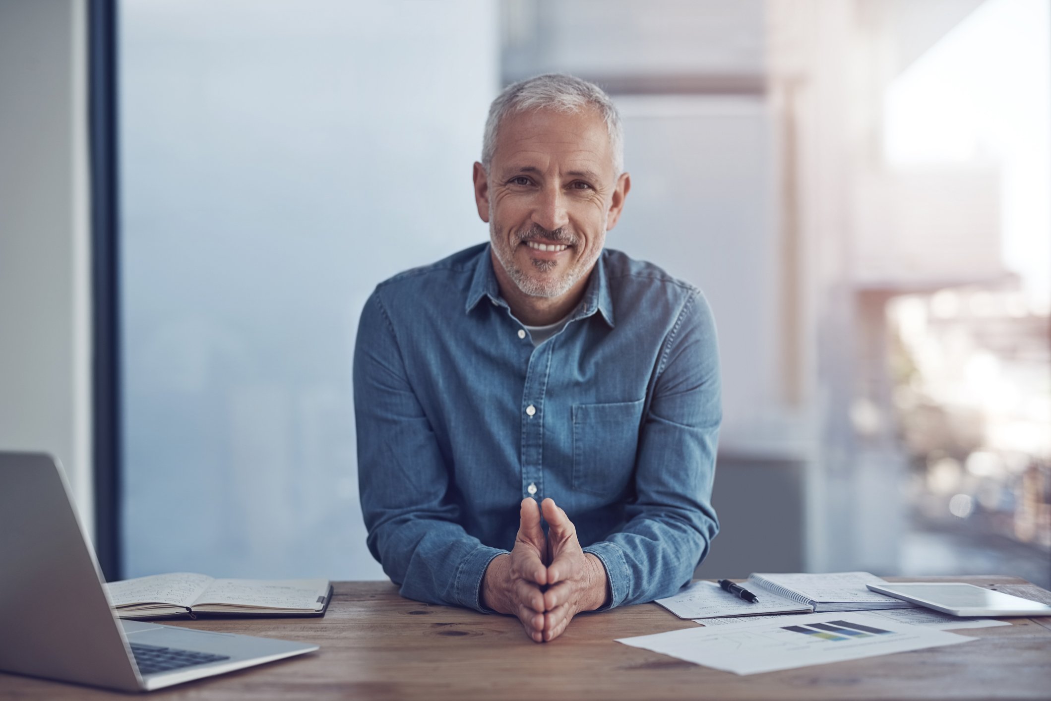 A smiling person at a desk.