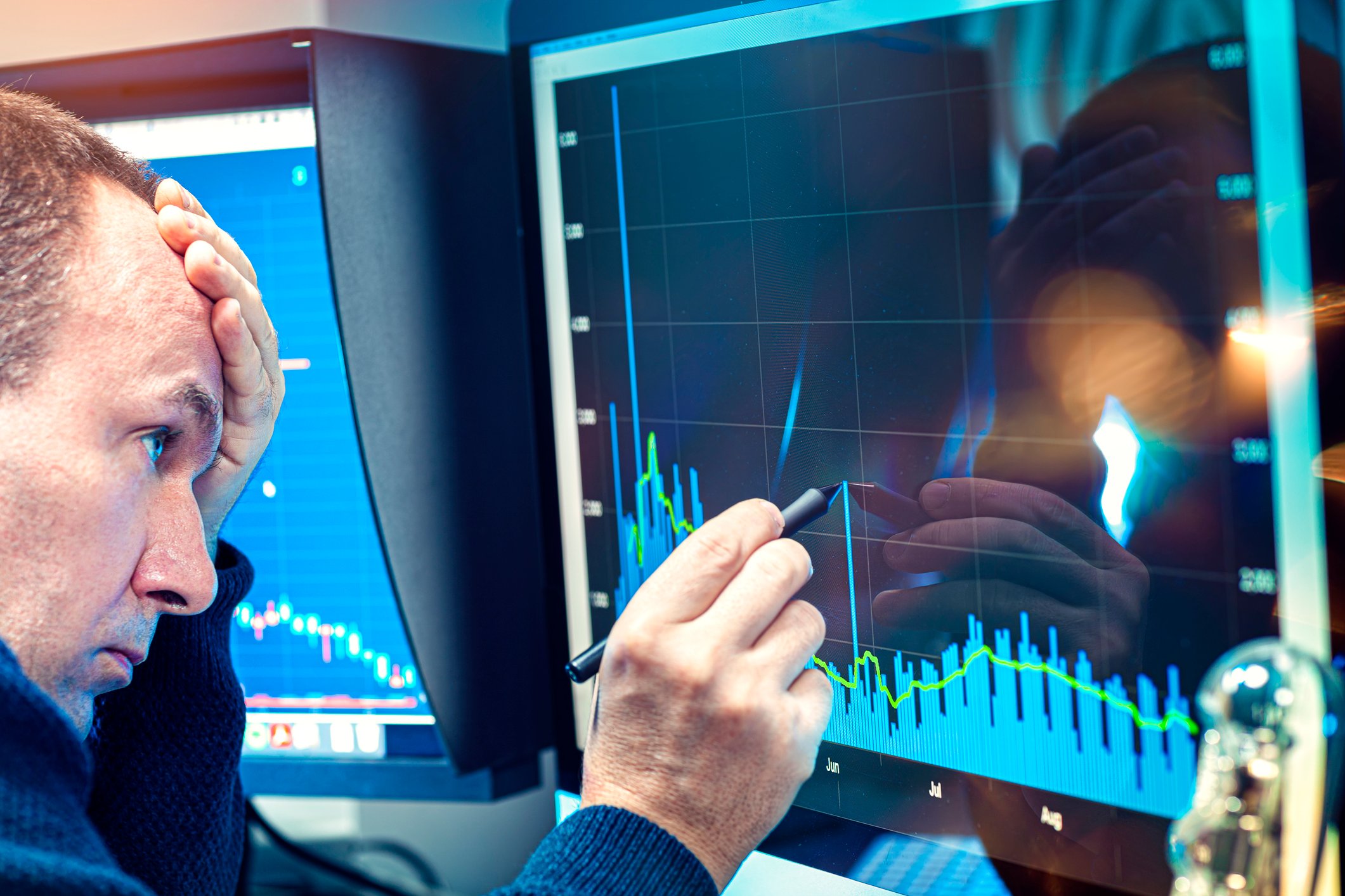 Worried investor analyzing a troubling stock chart on a computer screen.