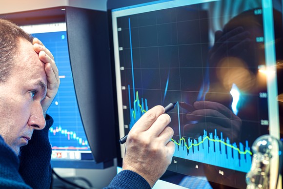 Worried investor analyzing a troubling stock chart on a computer screen.