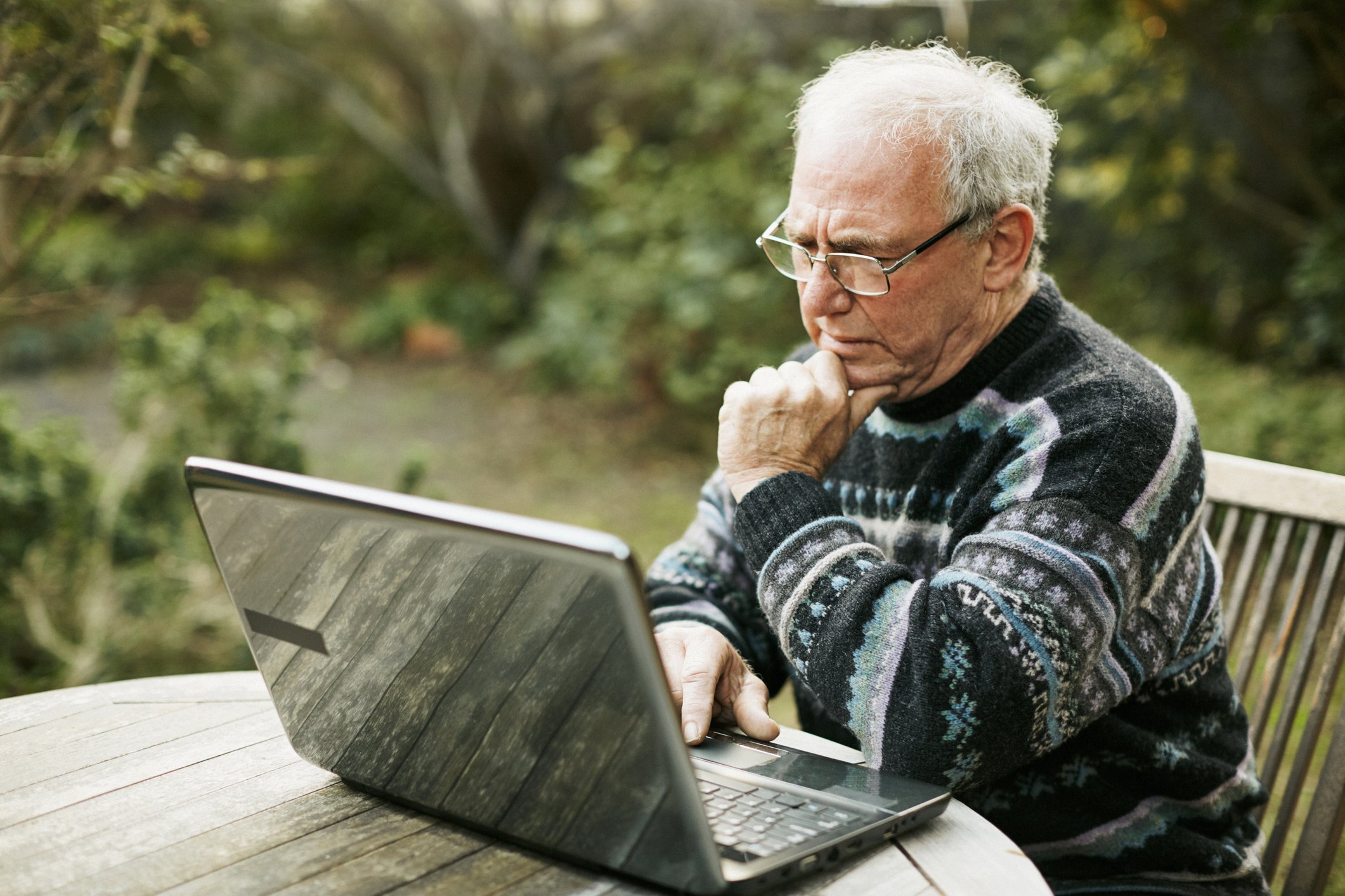 A person at a laptop outdoors.
