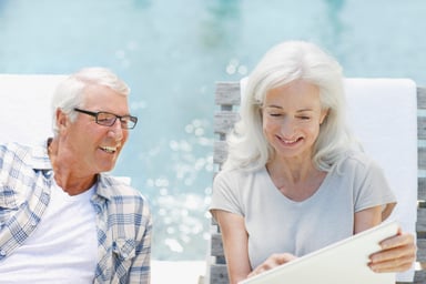 GettyImages-couple uses laptop by pool