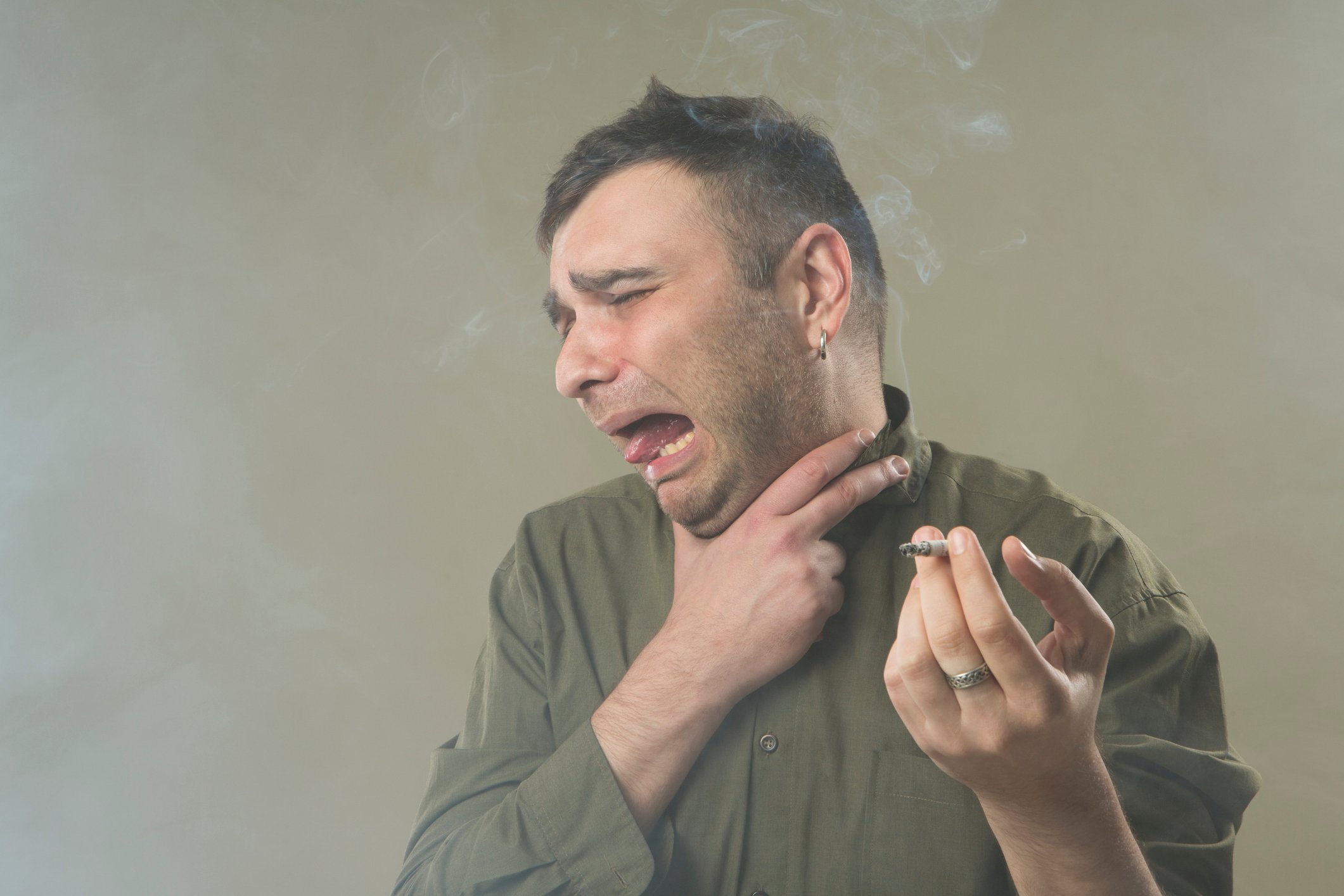 Man choking on marijuana cigarette.