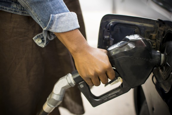Person holding gas pump handle.