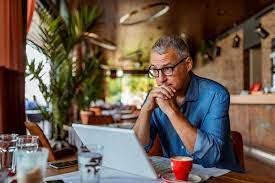 A person wearing glasses looking at laptop