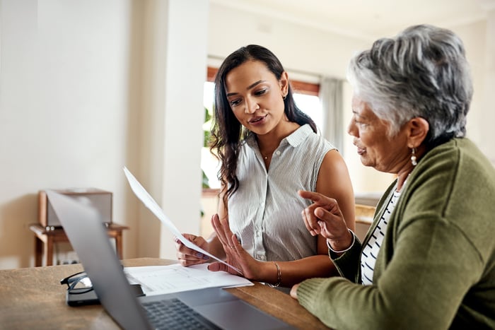 Young woman explaining data to elderly woman.