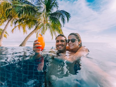 couple relaxes in pool at a beach setting