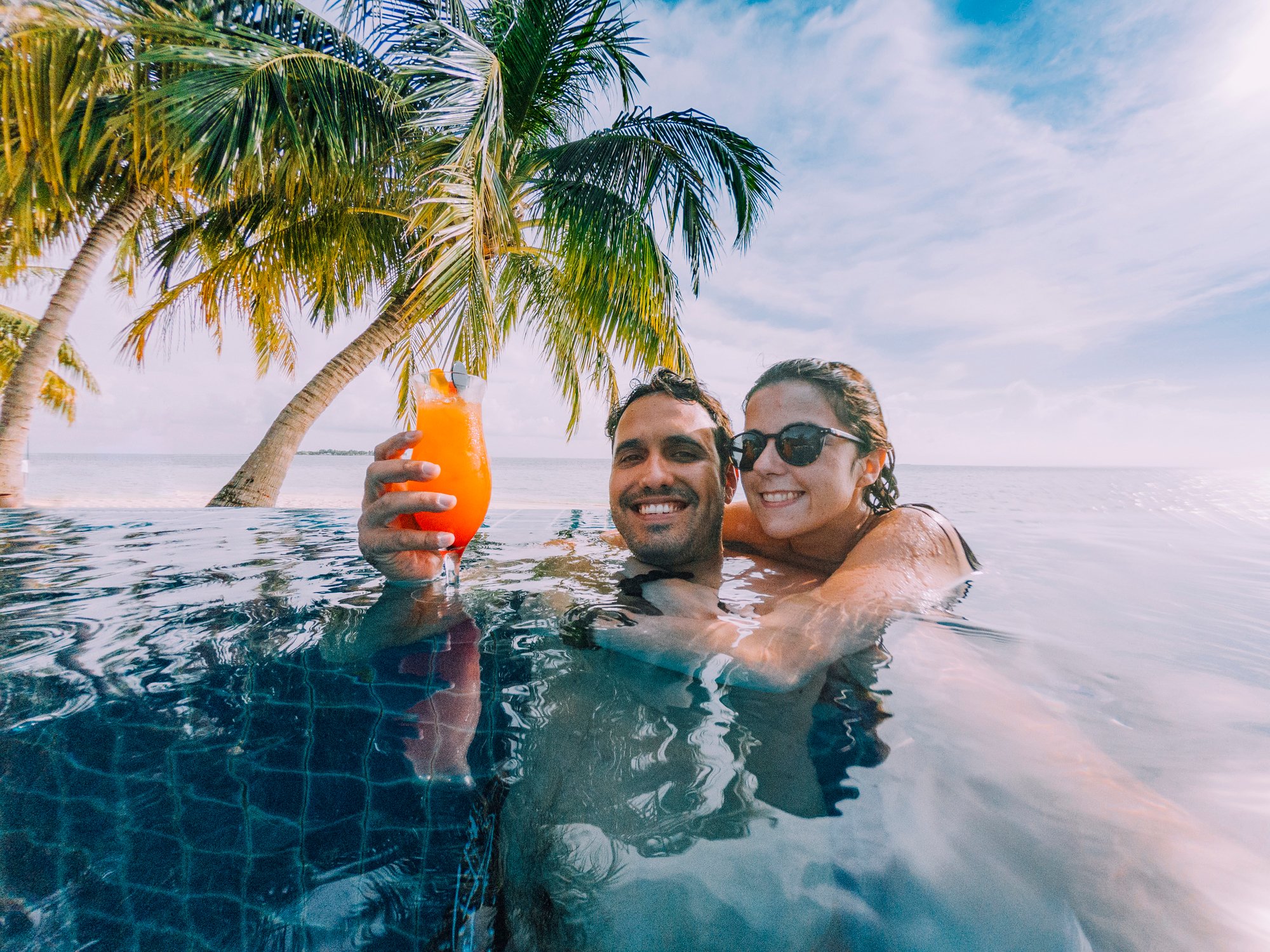 couple relaxes in pool at a beach setting