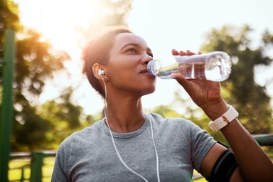 A jogger drinks from a bottle of water.