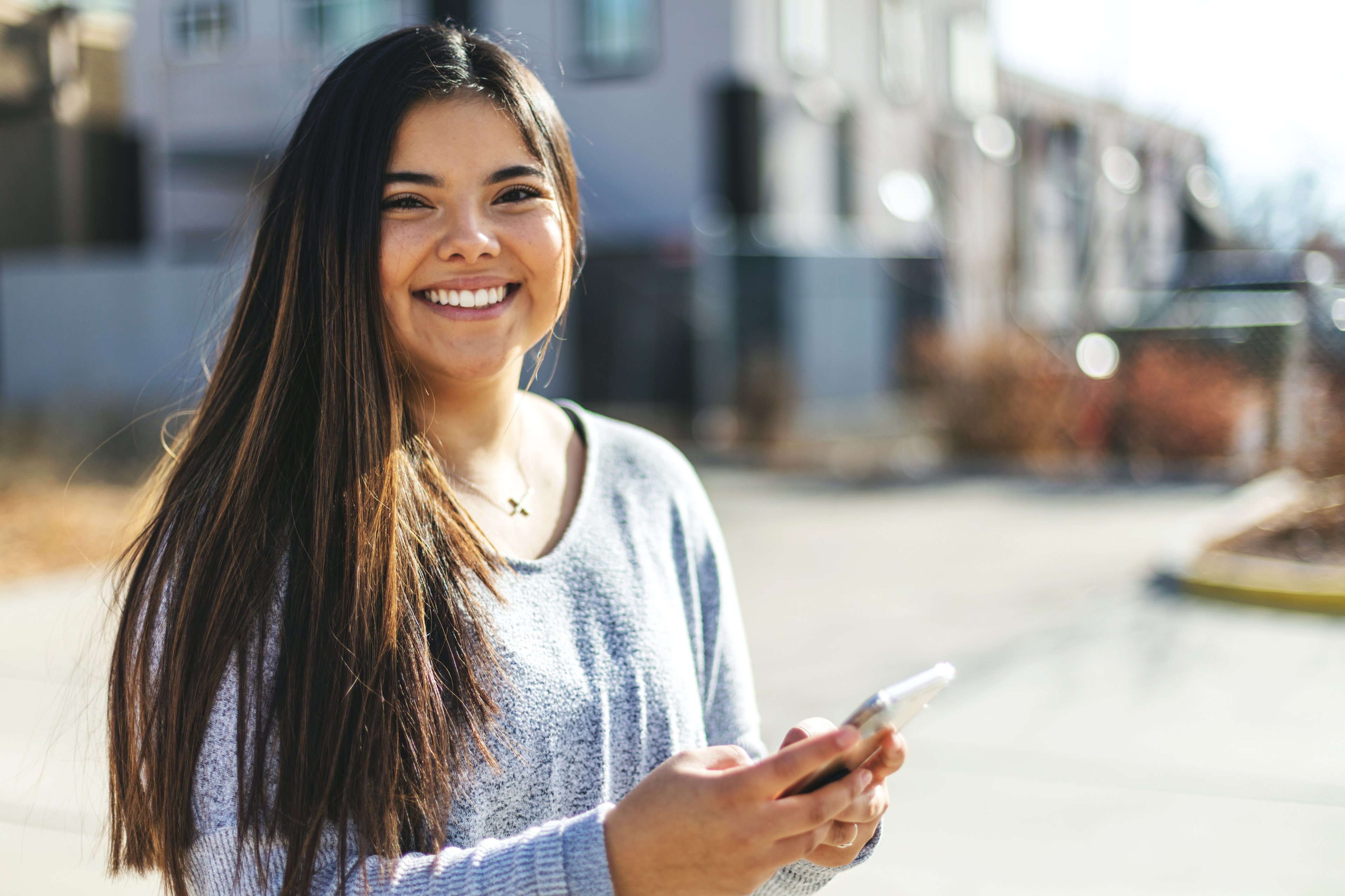 Someone smiling while holding a phone.