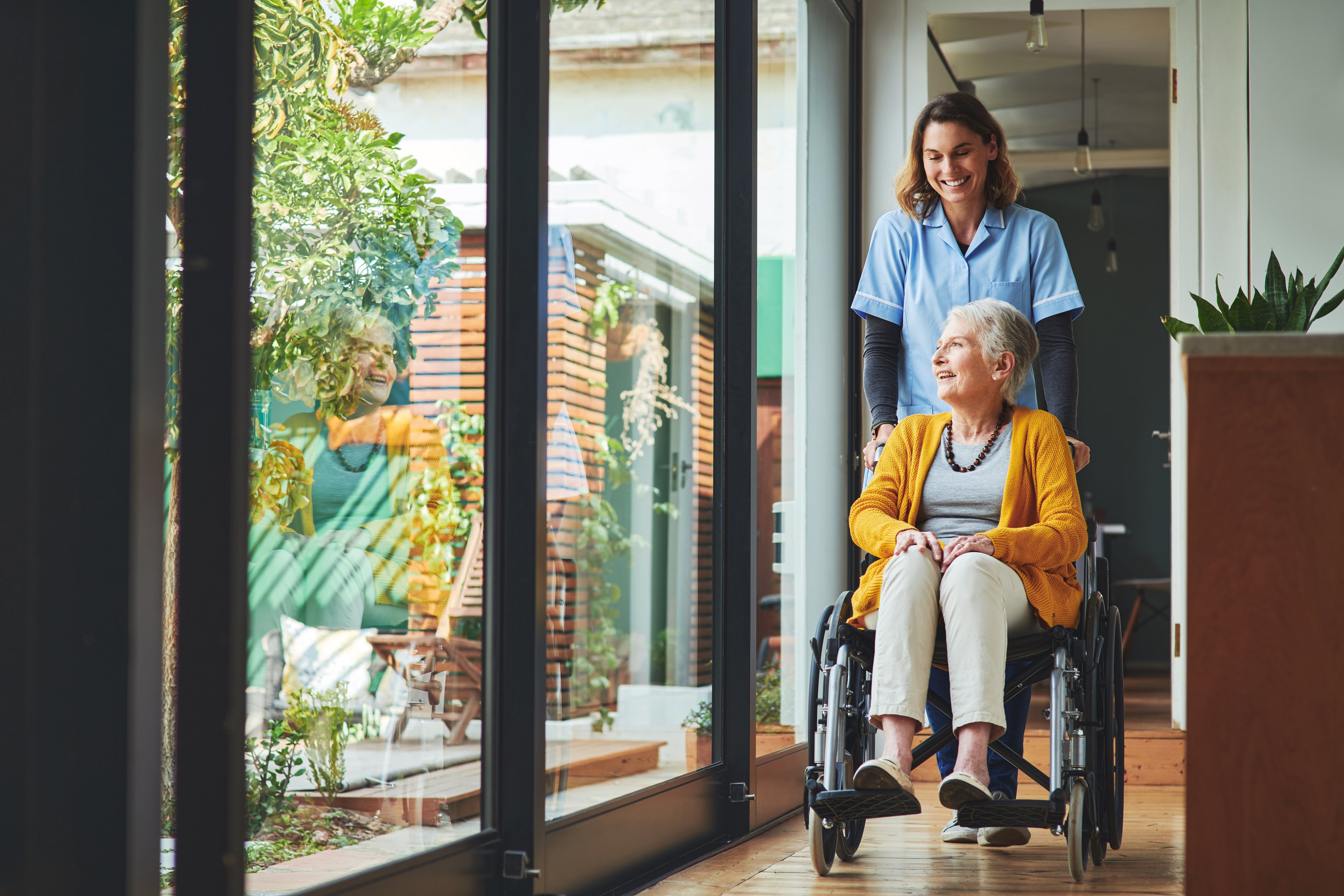 Healthcare worker pushing a senior in a wheelchair.