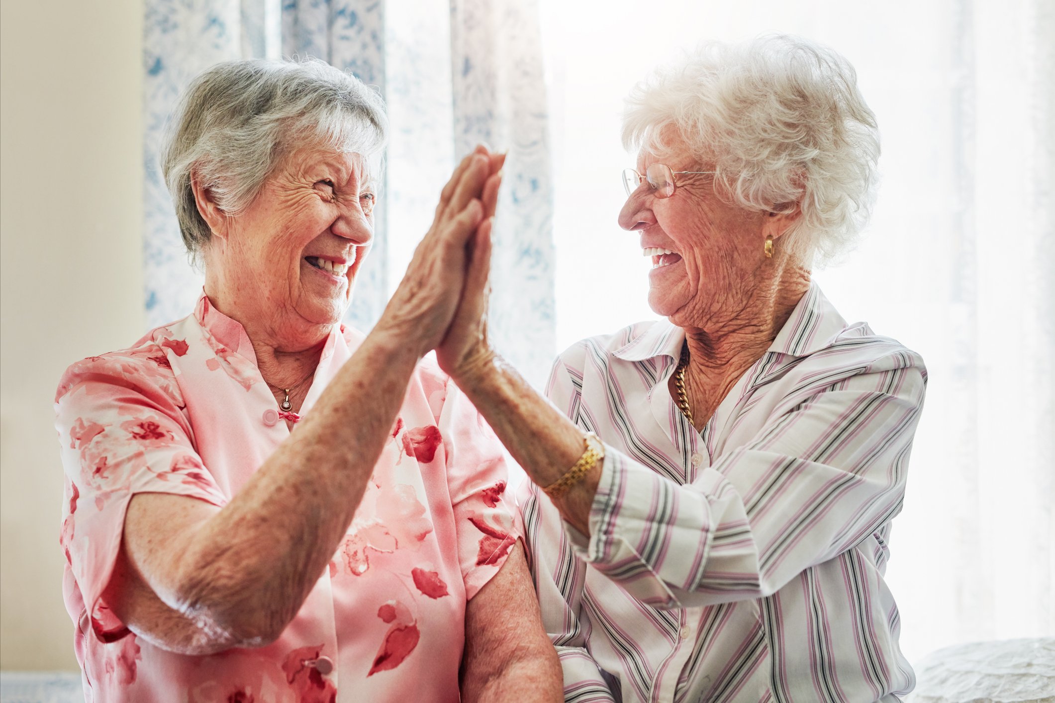 Two smiling people exchange high-fives.