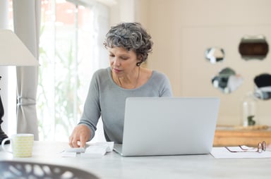 person sitting at table in front of computer