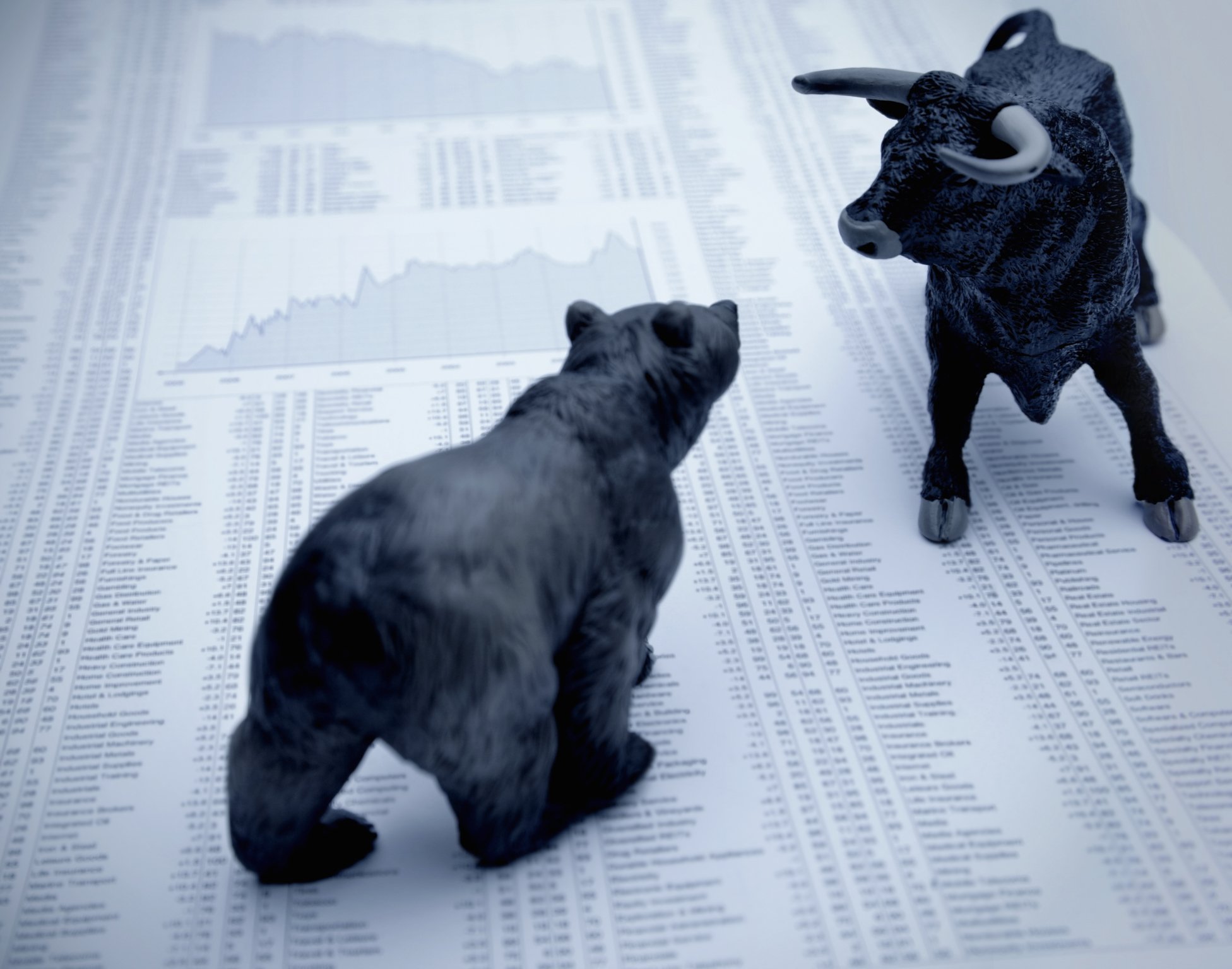 Bull and bear squaring off over stock pages.
