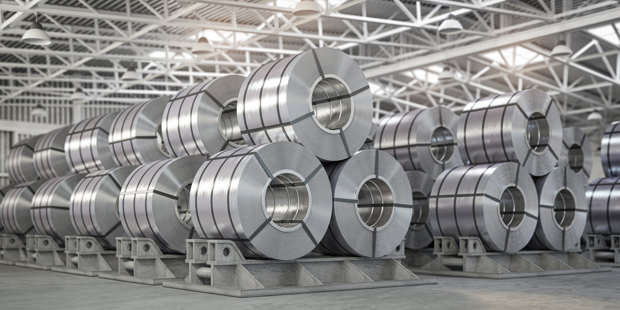 Galvanized steel coils stacked in a warehouse.