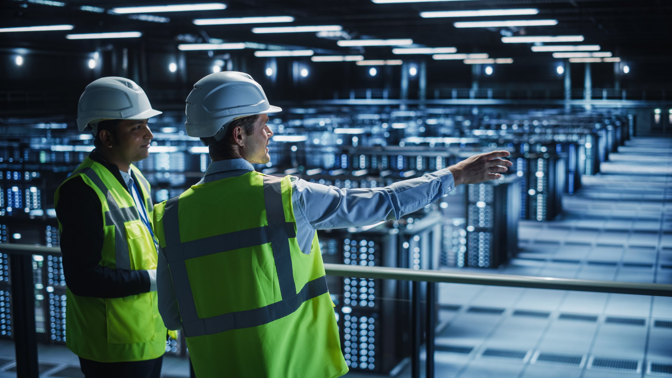 People wearing hard hats in a data center.