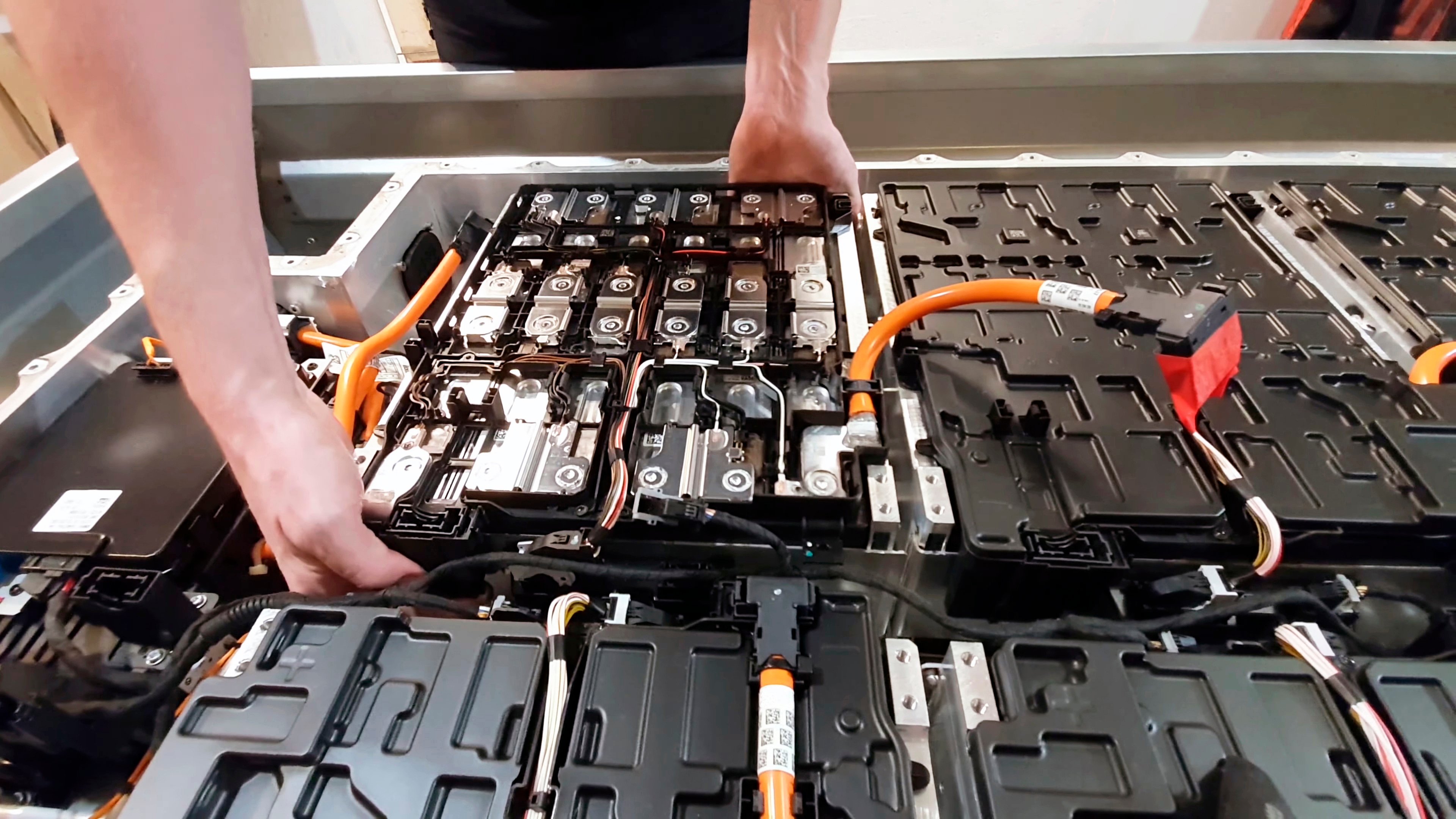 Worker installing battery cell in EV battery pack. 
