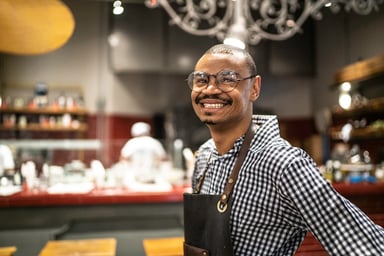Happy waiter working at restaurant