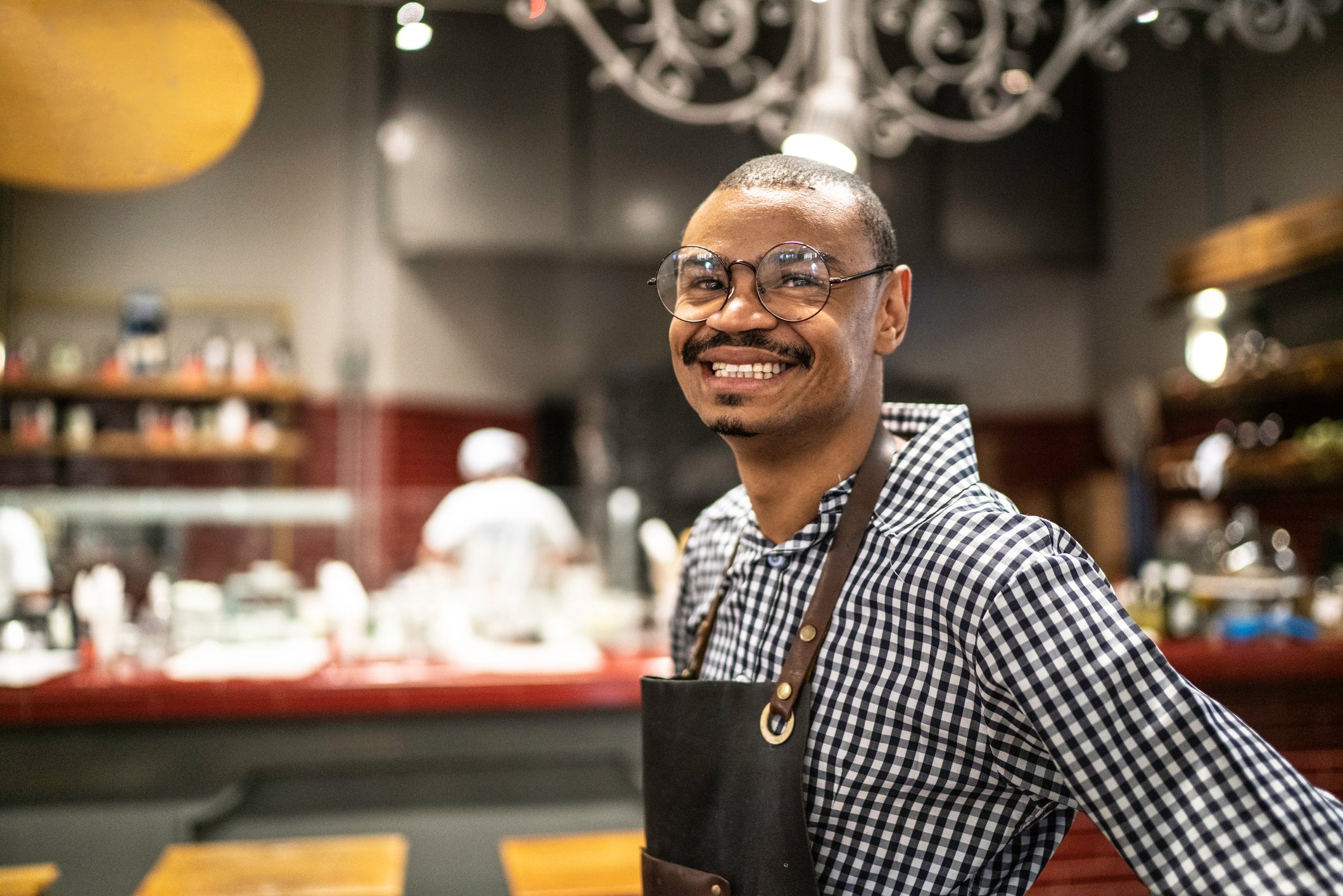 Happy waiter working at a restaurant.