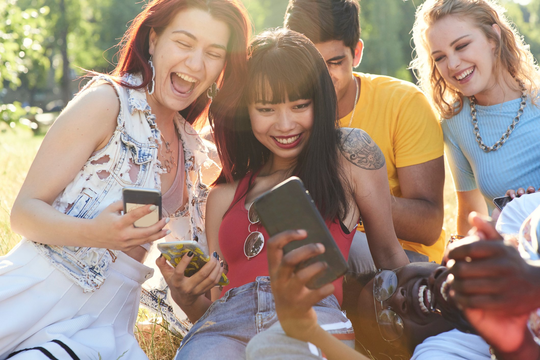 Group of friends laughing while on their phones