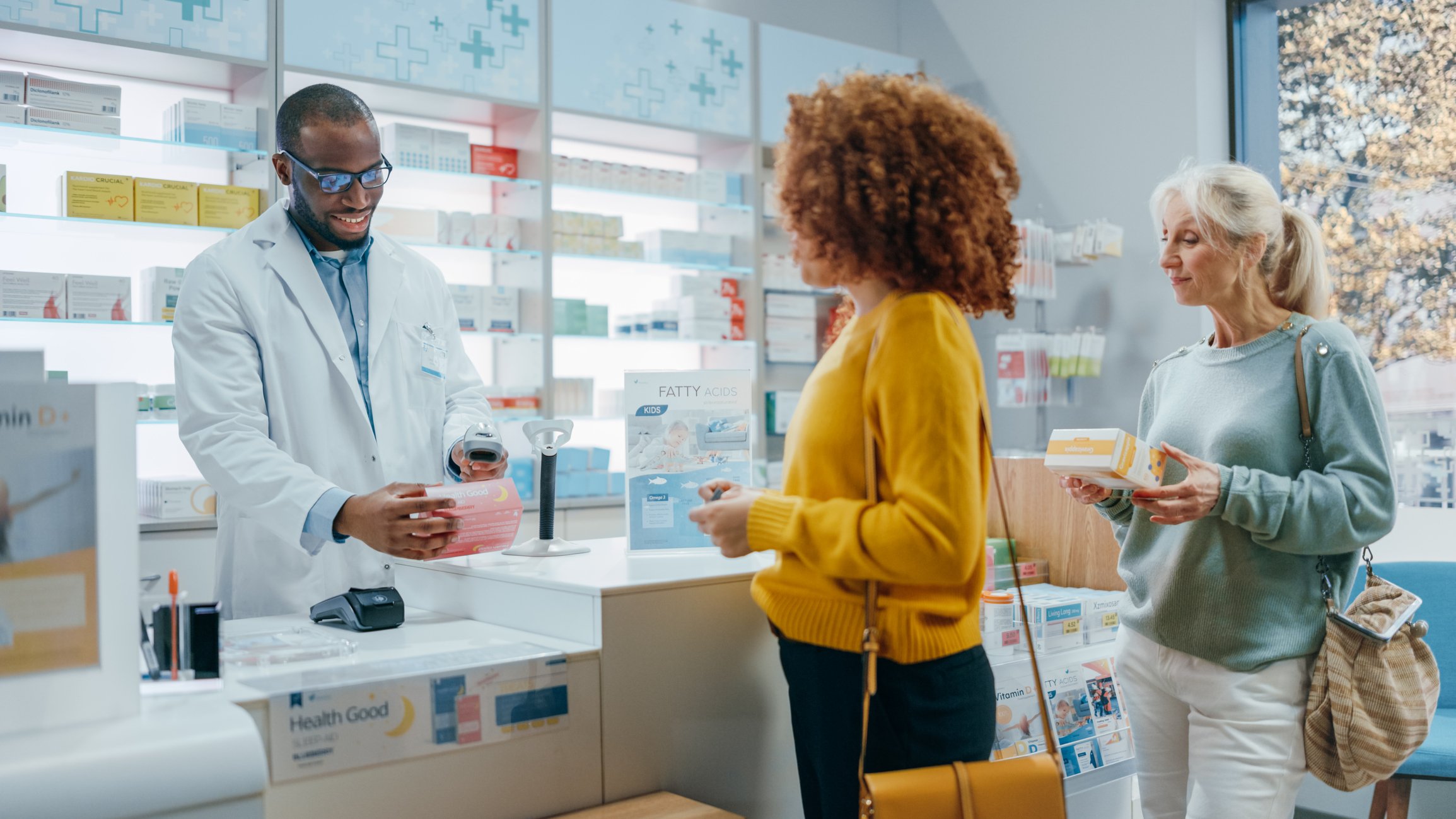 A pharmacist serves customers at a pharmacy.