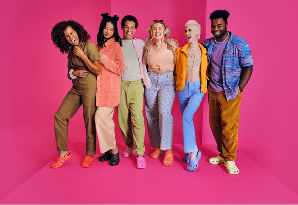 Six people showing off their Crocs.