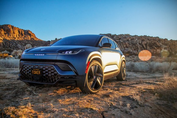 blue electric Fisker Ocean SUV in scenic setting.