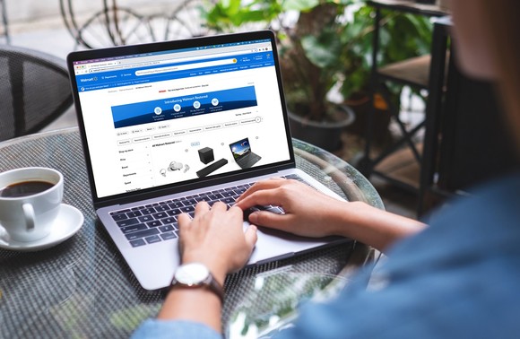 Person on laptop browsing Walmart Restored website.