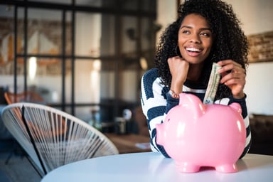 woman putting money in piggy bank